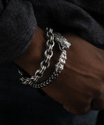 Man wears two silver men's bracelets