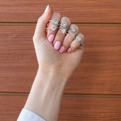 Woman models variety of diamond engagement rings from Fink's Jewelers