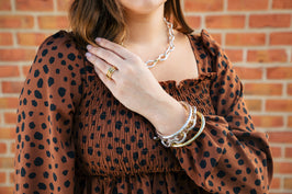 Woman Wearing Silver Jewelry in Front of Brick Wall