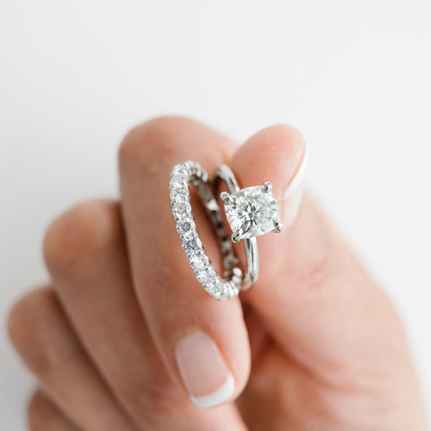 Woman holding sparkling clean diamond engagement ring and wedding band