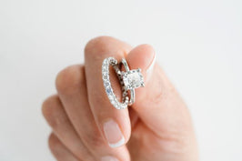 Woman holds up engagement and wedding ring set