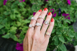 Woman's Hand Displaying Six Diamond Engagement Rings