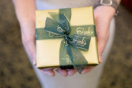 Woman holding gift-wrapped jewelry from Fink's Jewelry