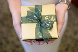 Person holding Fink's Jewelry wrapped gift box