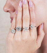 woman wearing four different engagement rings with various diamond shapes